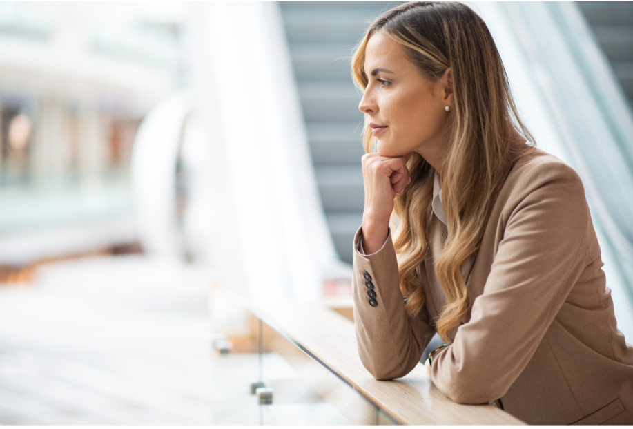 A career-driven woman in a tan business suit is taking a break and reflecting.