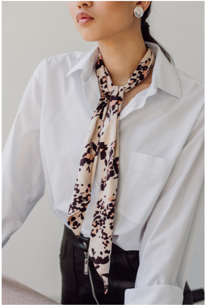 Career woman in a white blouse with a neck scarf.