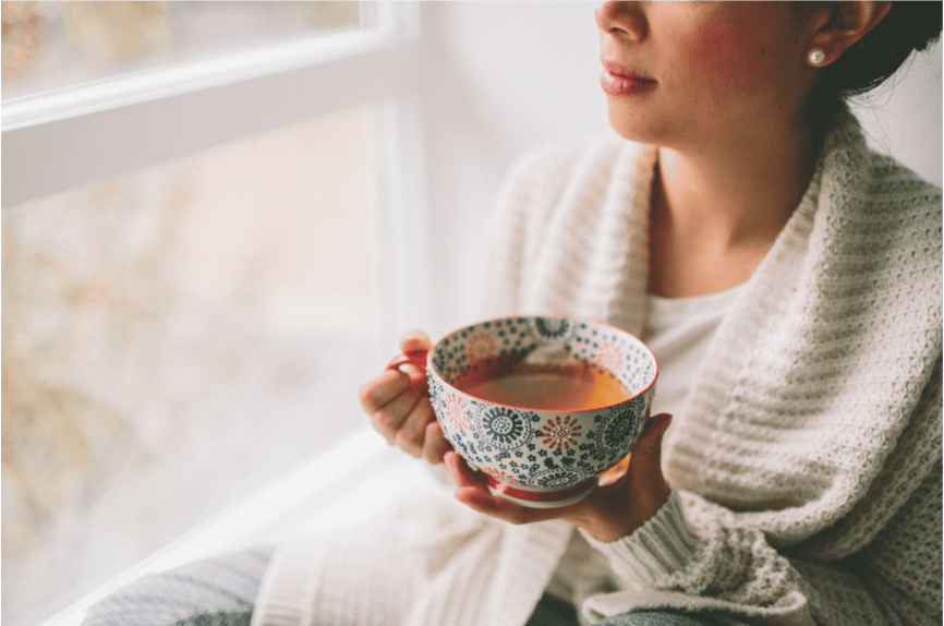 A woman savoring tea as a conscious foodie.