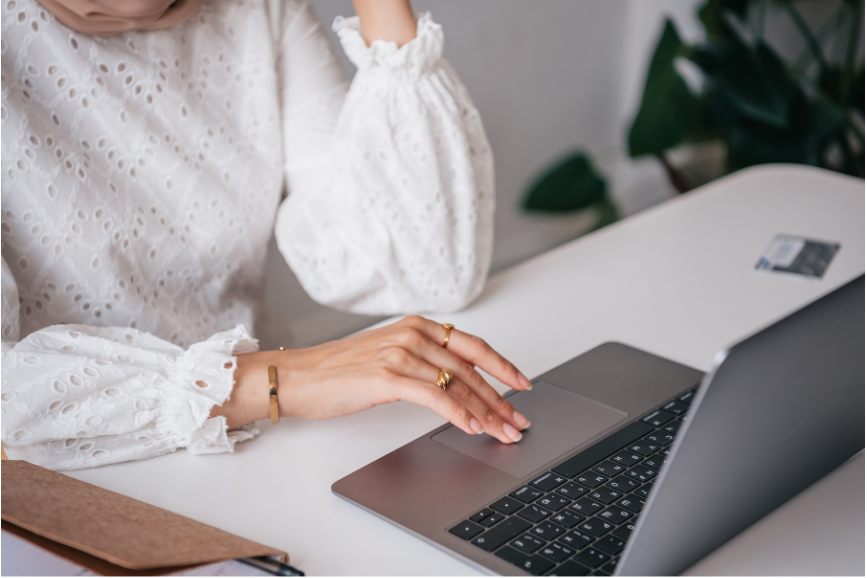 A woman's hand is typing on a laptop.