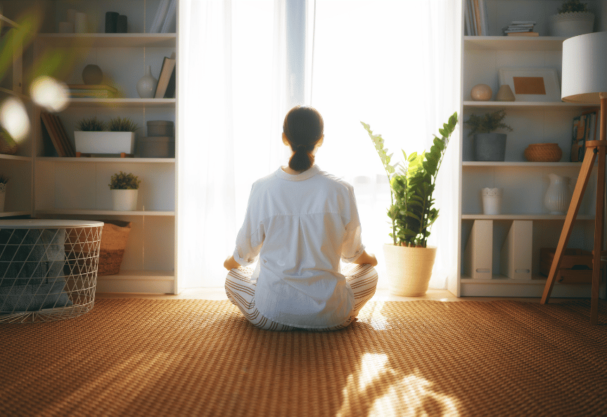 A women is meditating in the morning sunshine to set up her day for higher performance.