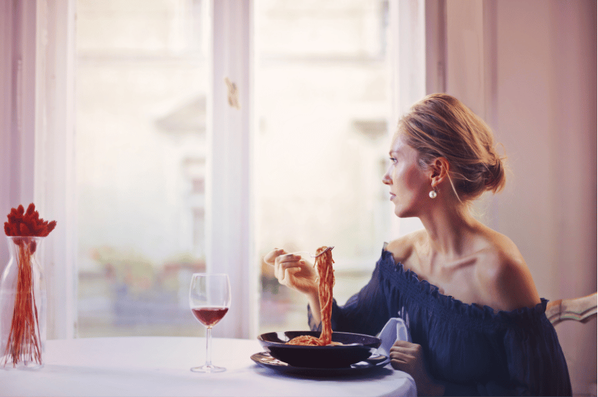 A woman enjoying an elegant eating experience.