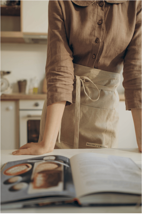 Woman is reading a cookbook to learn how to cook at home.