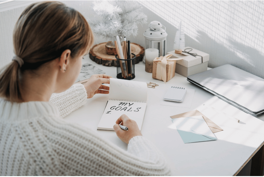 A woman writing her goals to support her high performance mindset.