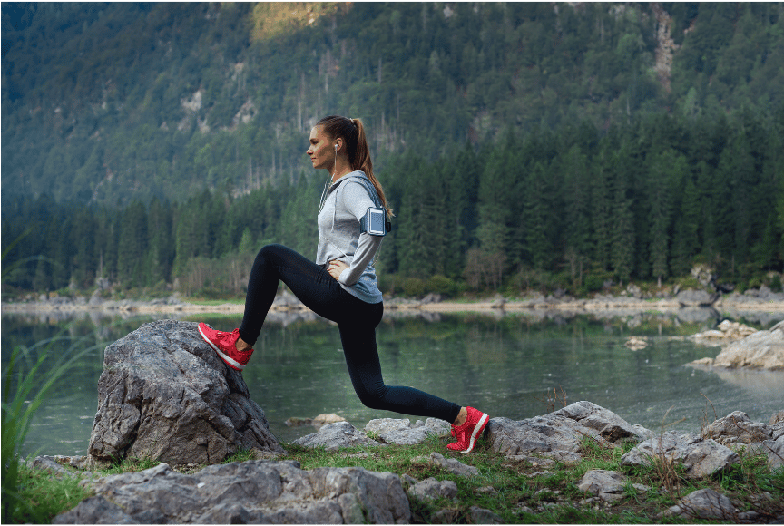 A woman demonstrating travel and fitness with an outdoor workout in nature.