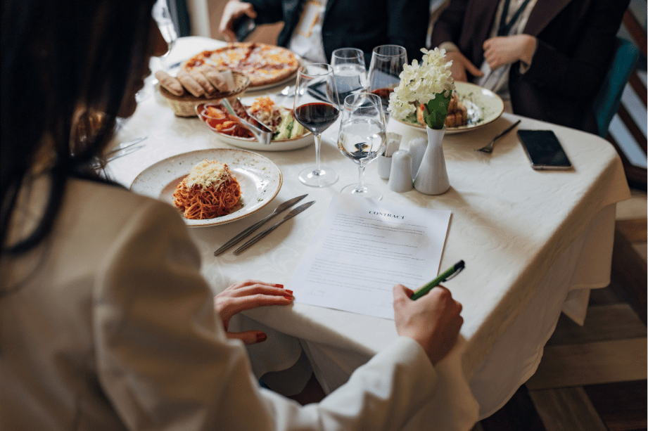 A career woman signing a contract at a work dinner.