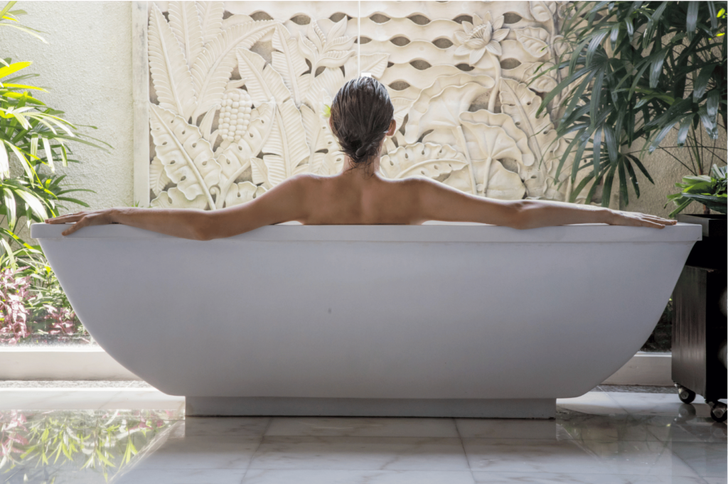 woman soaking in the bath as part of her daily self care checklist.
