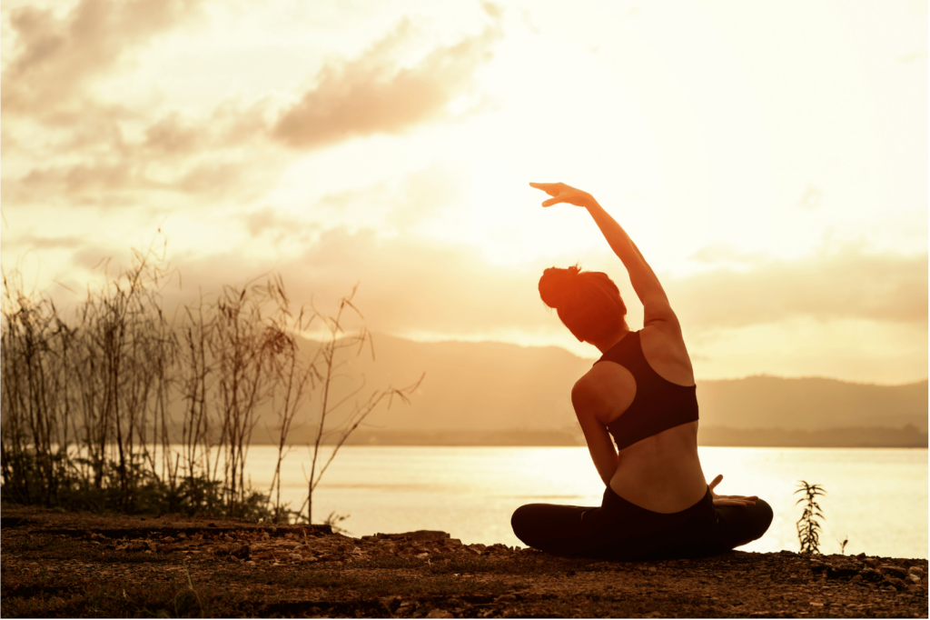woman stretching her body in nature as part of a daily self-care checklist.
