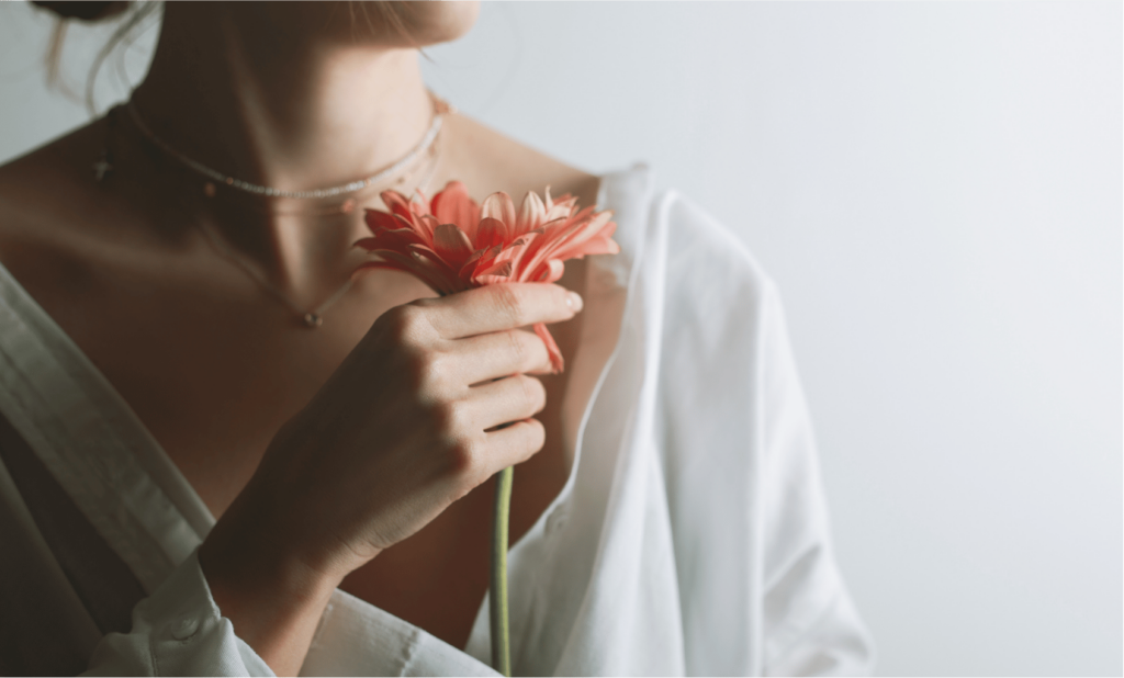 Woman holding flower to express the sacred feminine.